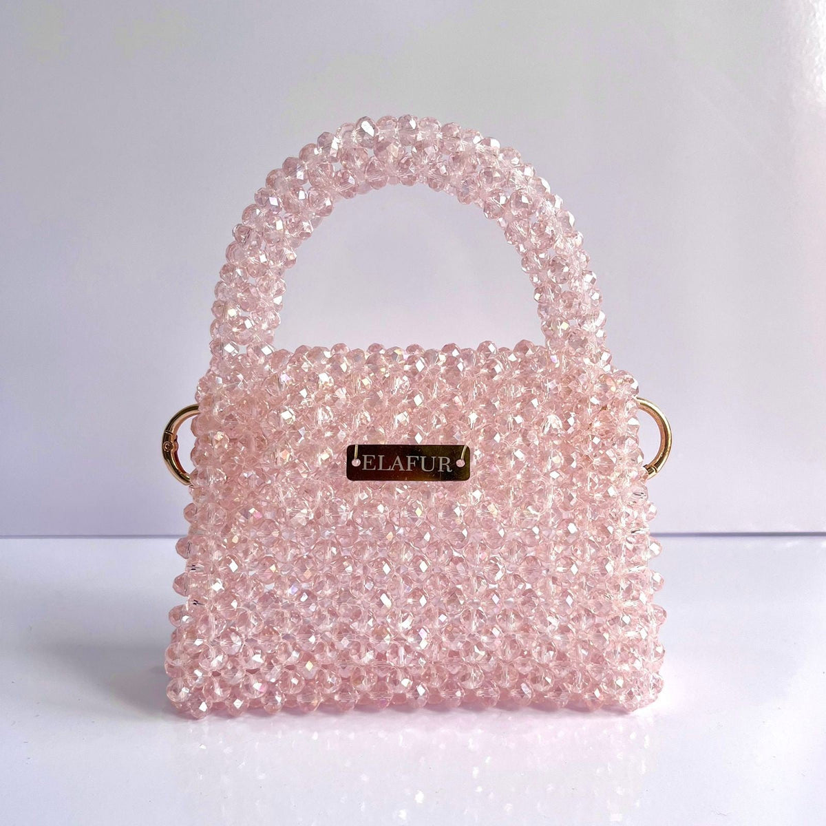 Elafur pink beaded mini handbag with a structured silhouette, gold-tone logo plaque, and matching gold hardware.